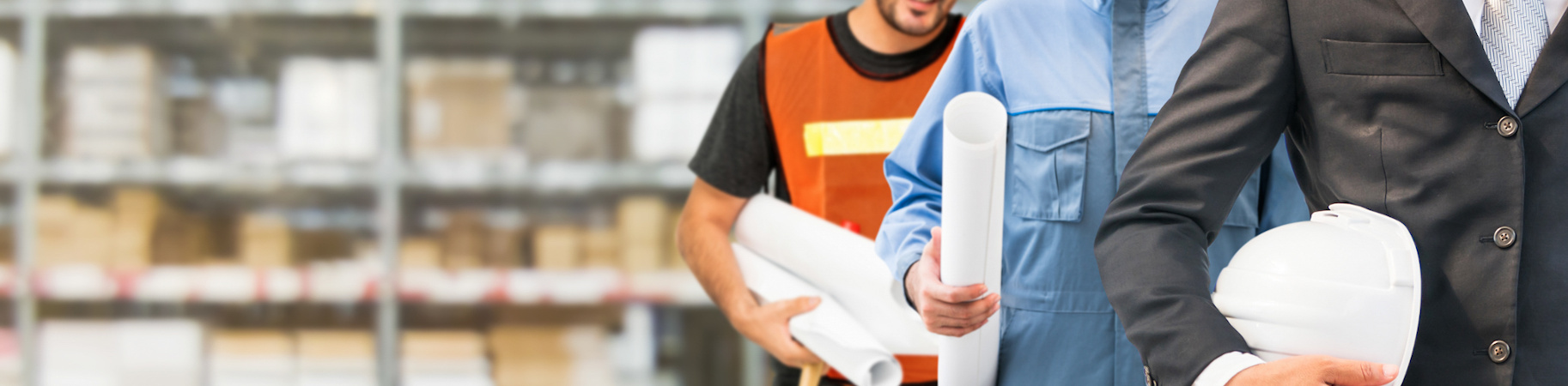 Three people from varying industries standing in a warehouse