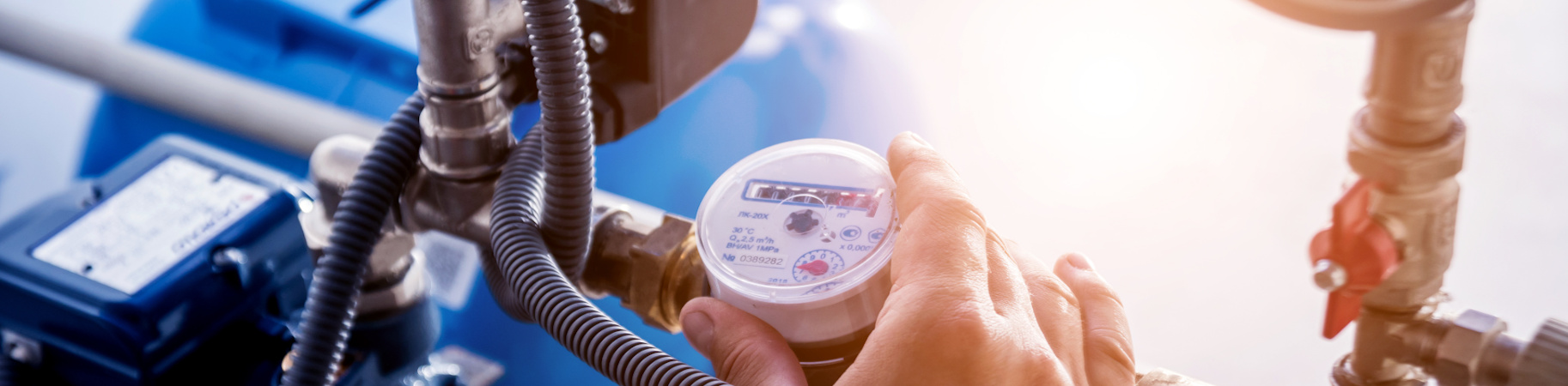 Someone adjusting the knob of a valve on an HVAC unit