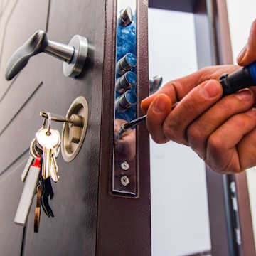 Someone installing a lock on a door