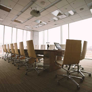Office boardroom containing furniture including large table and chairs