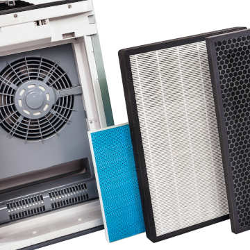 An air filtration unit with different filter pads pictured next to it