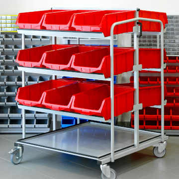 A metal shelf holding three racks lined with red plastic storage bins